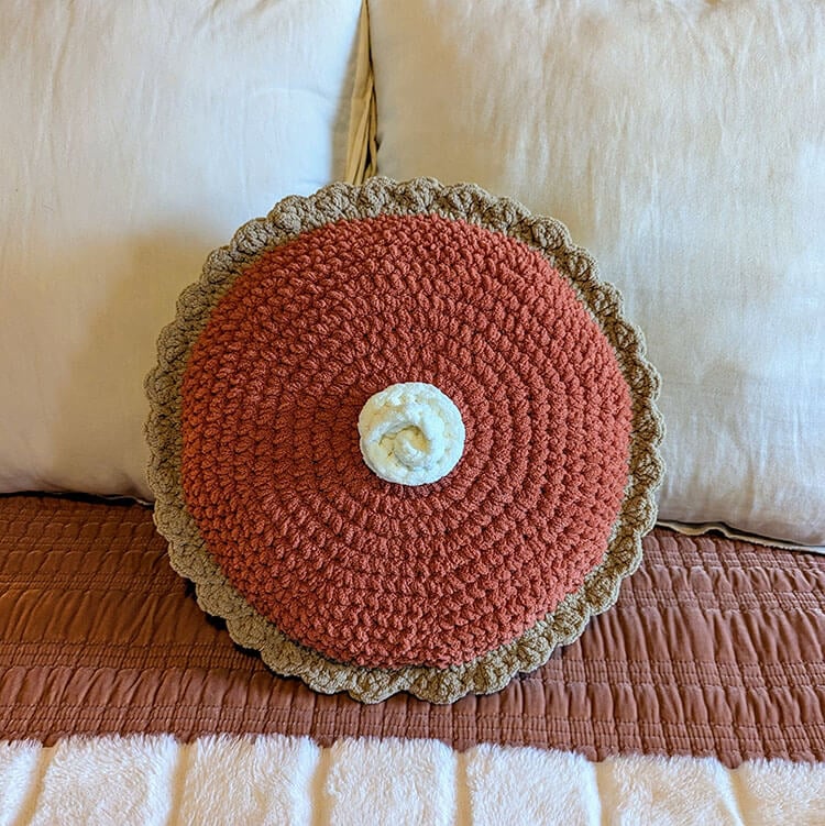giant pumpkin pie pillow on bed